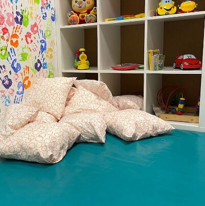 stanza di una scuola dell'infanzia con cuscini e giochi